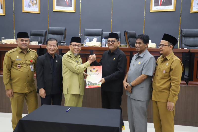 Wakil Ketua DPRD Mastilizal Aye serahkan keputusan DPRD kepada Wakil Walikota Padang Maigus Nasir usai pengesahan Pencabutan Perda No. 5 tahun 2003.